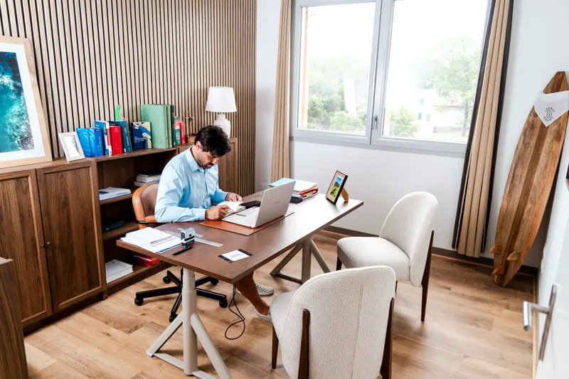 Vue d’ensemble du bureau de Serbat Avocats : lumière naturelle, chaises et planche de surf en bois